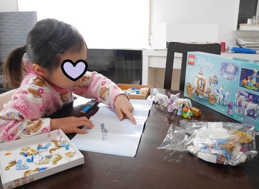 ディズニープリンセスのレゴの「シンデレラの馬車」の説明書を見ている6歳女の子