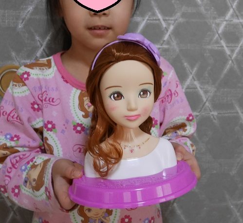 ヘアメイクアーティストの人形を手にしている6歳の女の子
