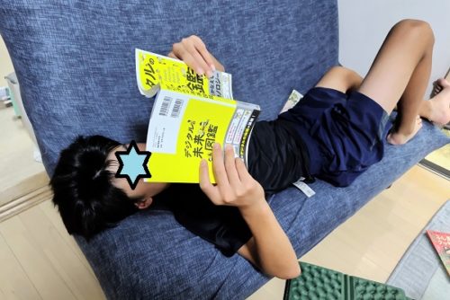 デジタルの未来図鑑を読む中学生の男の子