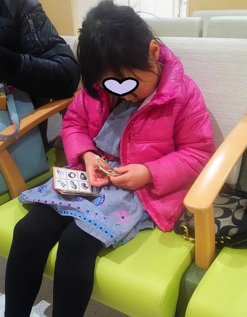 はずるのキャストハーモニーを病院の待合室で遊んでいる5歳女の子